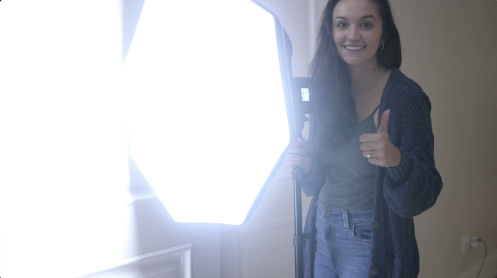 photo of photographer holding a rapid box softbox and video light